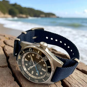 HAND-BUILT GMT DIVERS WATCH HADAL'65 showcasing its 200m water resistance by the beach.